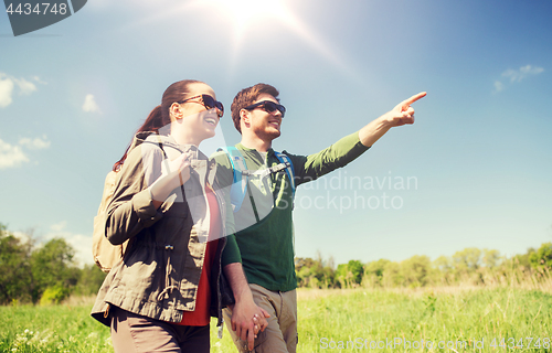 Image of happy couple with backpacks hiking outdoors