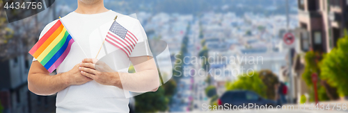 Image of man with gay pride rainbow flag and american