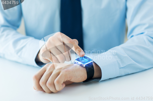 Image of close up of hands with bitcoin on smart watch