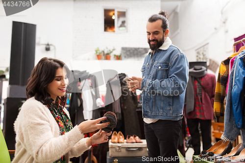 Image of couple choosing footwear at vintage clothing store