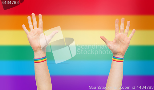 Image of hands with gay pride rainbow wristbands