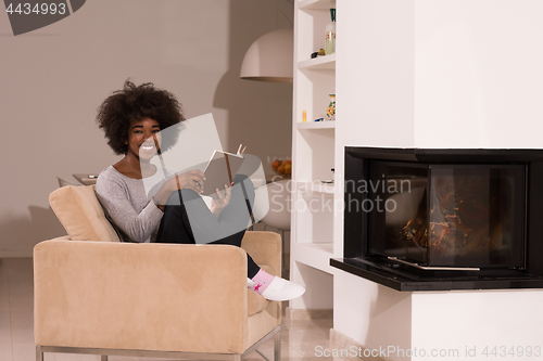 Image of black woman at home reading book