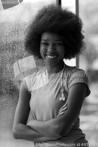 Image of portrait of young afro american woman in gym while listening mus