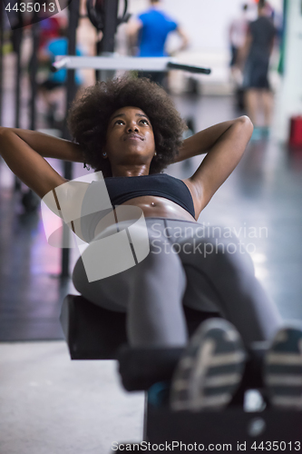 Image of black woman doing sit ups at the gym