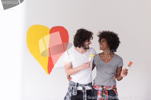 Image of couple with painted heart on wall