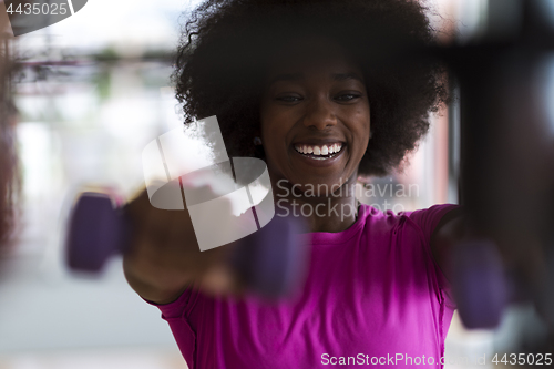 Image of woman working out in a crossfit gym with dumbbells