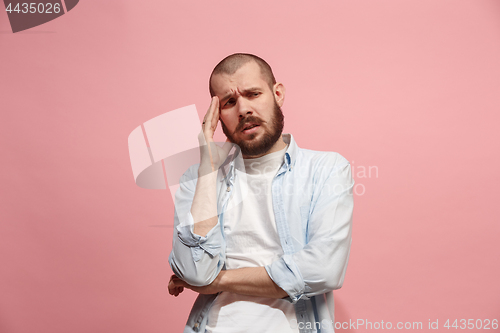 Image of Man having headache. Isolated over pink background.