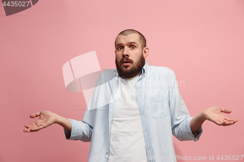 Image of Let me think. Doubtful pensive man with thoughtful expression making choice against pink background