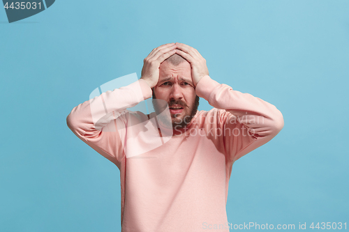 Image of Man having headache. Isolated over blue background.