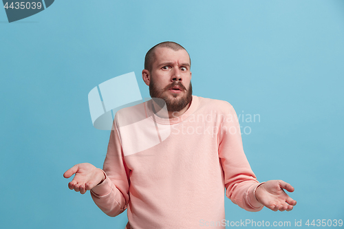 Image of Beautiful man looking suprised and bewildered isolated on blue