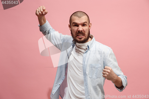 Image of The young emotional angry man screaming on pink studio background