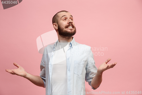 Image of The happy business man standing and smiling against pastel background.