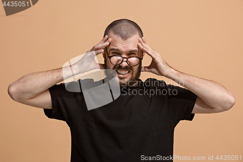 Image of Man having headache. Isolated over pastel background.