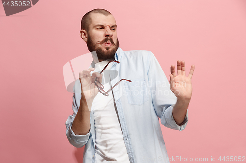 Image of Let me think. Doubtful pensive man with thoughtful expression making choice against pink background