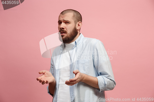 Image of Let me think. Doubtful pensive man with thoughtful expression making choice against pink background