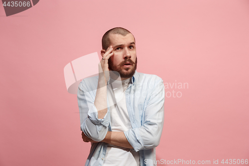 Image of Young serious thoughtful businessman. Doubt concept.