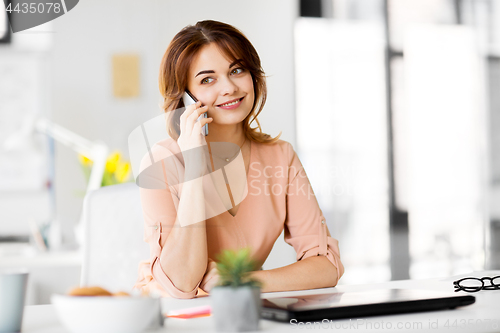 Image of businesswoman calling on smartphone at office