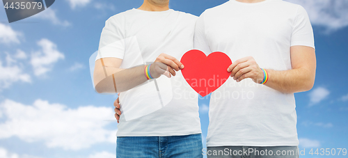 Image of couple with gay pride rainbow wristbands and heart