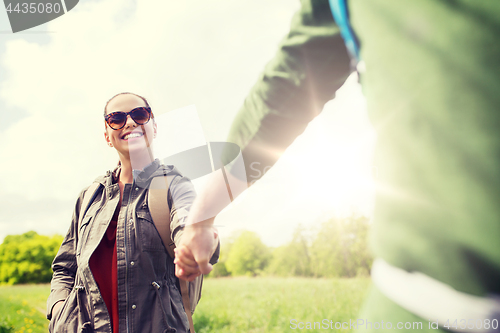 Image of happy couple with backpacks hiking outdoors