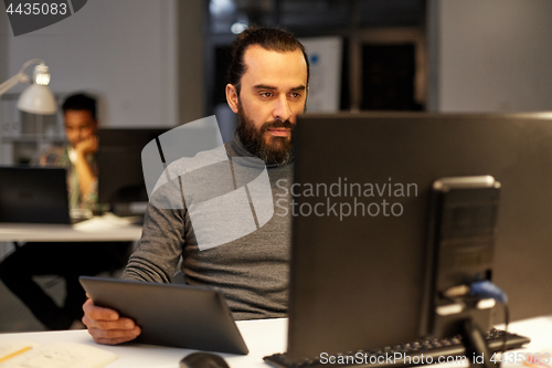 Image of creative man with computer working late at office