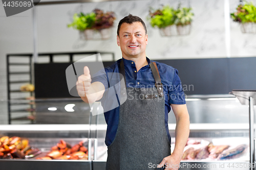 Image of seafood seller at fish shop showing thumbs up