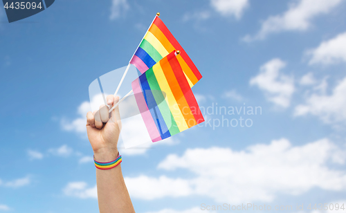 Image of hand with gay pride rainbow flags and wristband