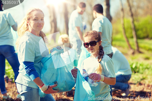 Image of volunteers with garbage bags cleaning park area