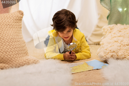 Image of boy with magnifier and map in kids tent at home