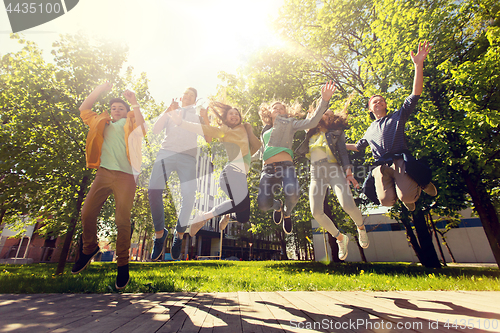 Image of happy teenage students or friends jumping outdoors