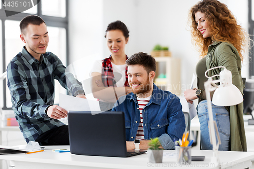 Image of creative team with laptop working at office