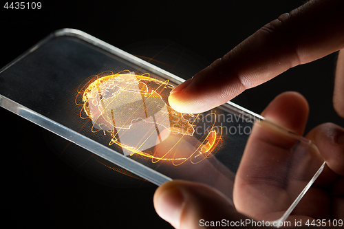 Image of hands with smartphone and earth hologram