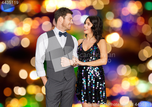 Image of happy couple hugging at party over festive lights 