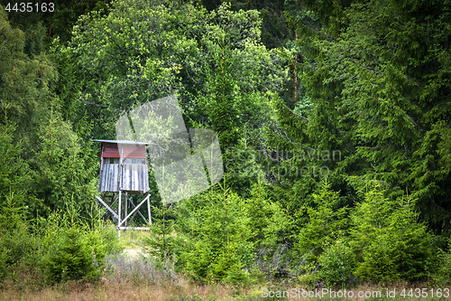 Image of Wooden hunting tower in a green forest