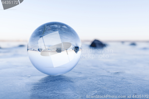 Image of Black rocks in a glass orb on a frozen lake