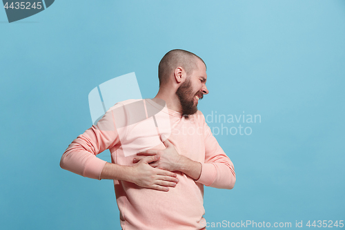 Image of Man having heart pain. Isolated over blue background.