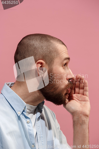 Image of Isolated on pink young casual man is gossiping at studio
