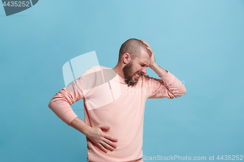 Image of Young man overwhelmed with a pain in the stomach .