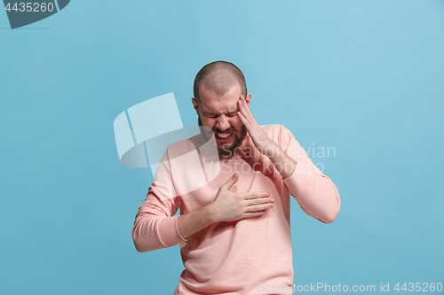 Image of Man having heart pain. Isolated over blue background.