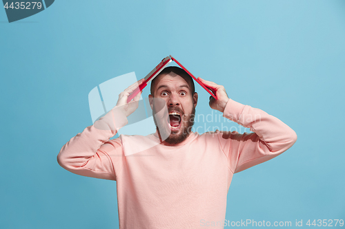 Image of Handsome man in stres with laptop isolated on blue