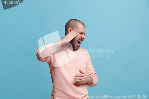 Image of Man having headache. Isolated over blue background.