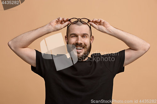 Image of The happy business man standing and smiling against pastel background.