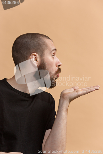 Image of Isolated on pastel young casual man kissing at studio