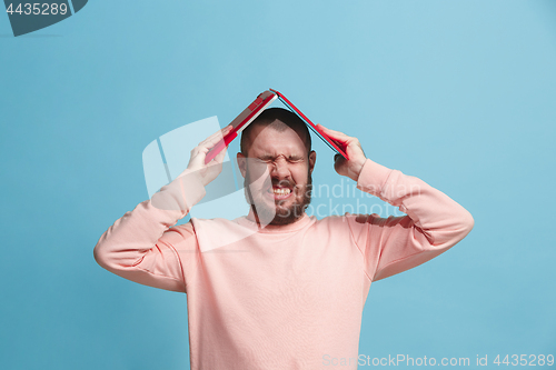 Image of Handsome man in stres with laptop isolated on blue