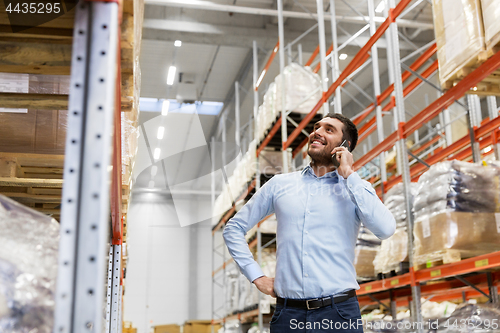 Image of businessman calling on smartphone at warehouse