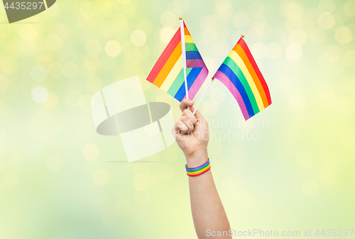 Image of hand with gay pride rainbow flags and wristband