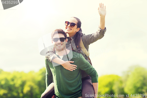 Image of happy couple with backpacks having fun outdoors