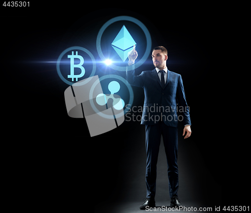 Image of buisnessman with cryptocurrency holograms