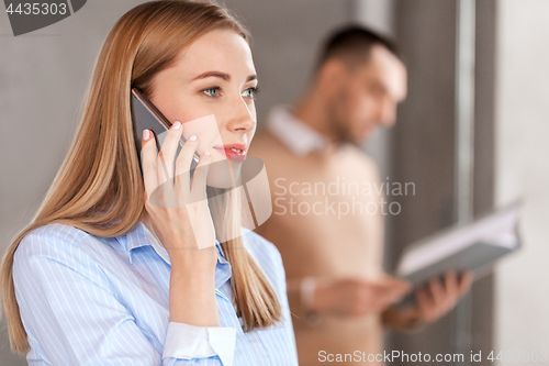 Image of businesswoman calling on smartphone at office