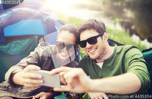 Image of couple of travelers taking selfie by smartphone