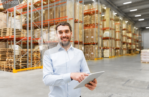 Image of happy businessman with tablet pc at warehouse